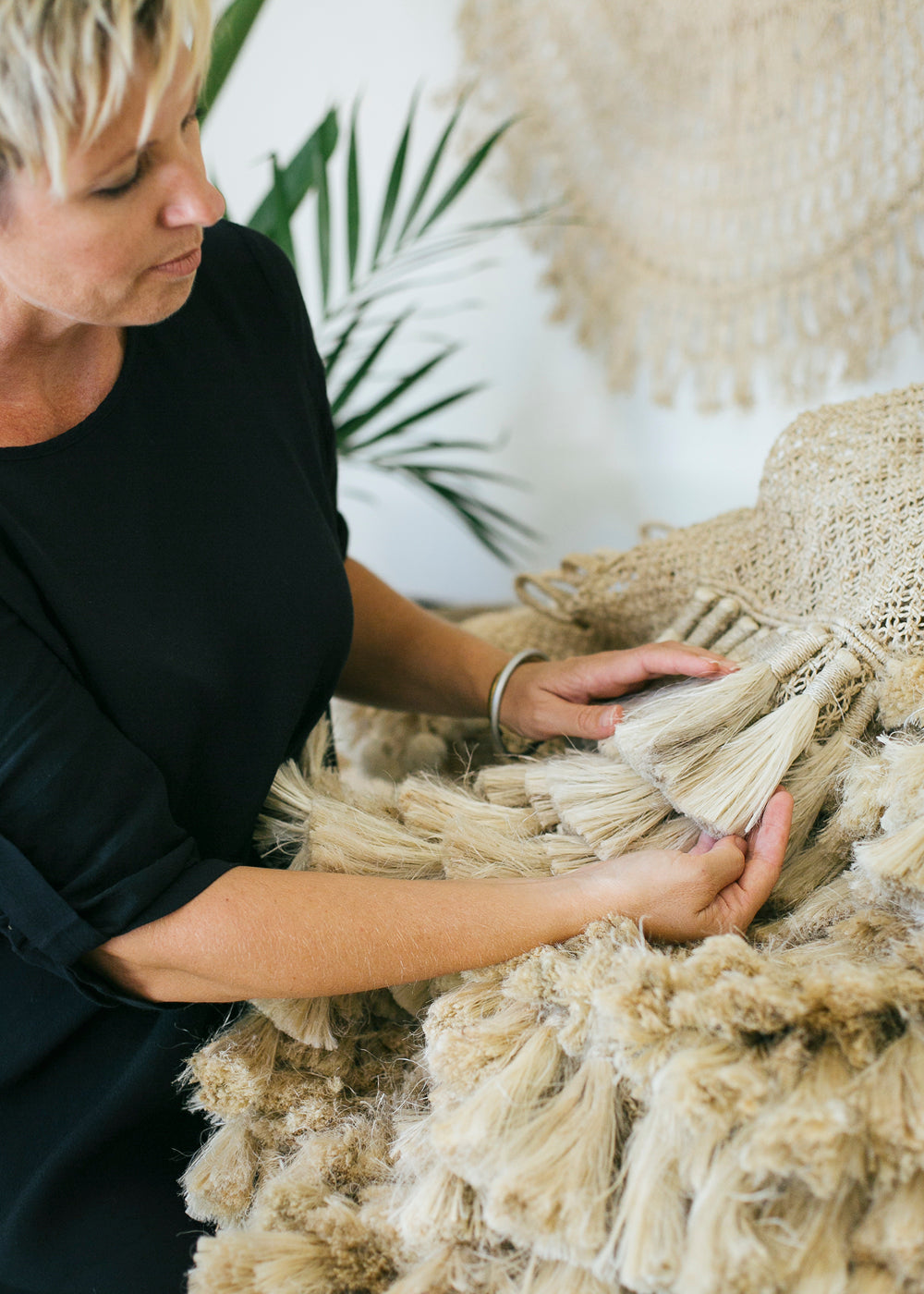 Fair trade  - Shannon Sheedy holding a jumbo tassle wall hanging.  