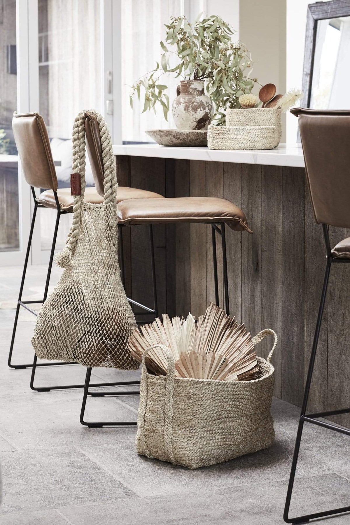 Small natural jute basket with string bag in kitchen 